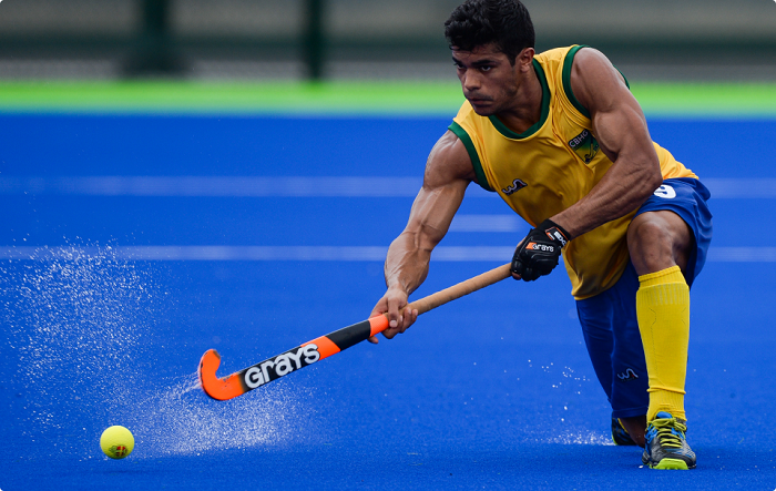 Jogador de hóquei em campo treinando e praticando o esporte na grama